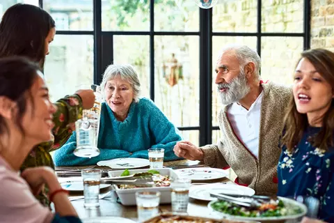 Eine Familie unterhält sich gut gelaunt beim Essen